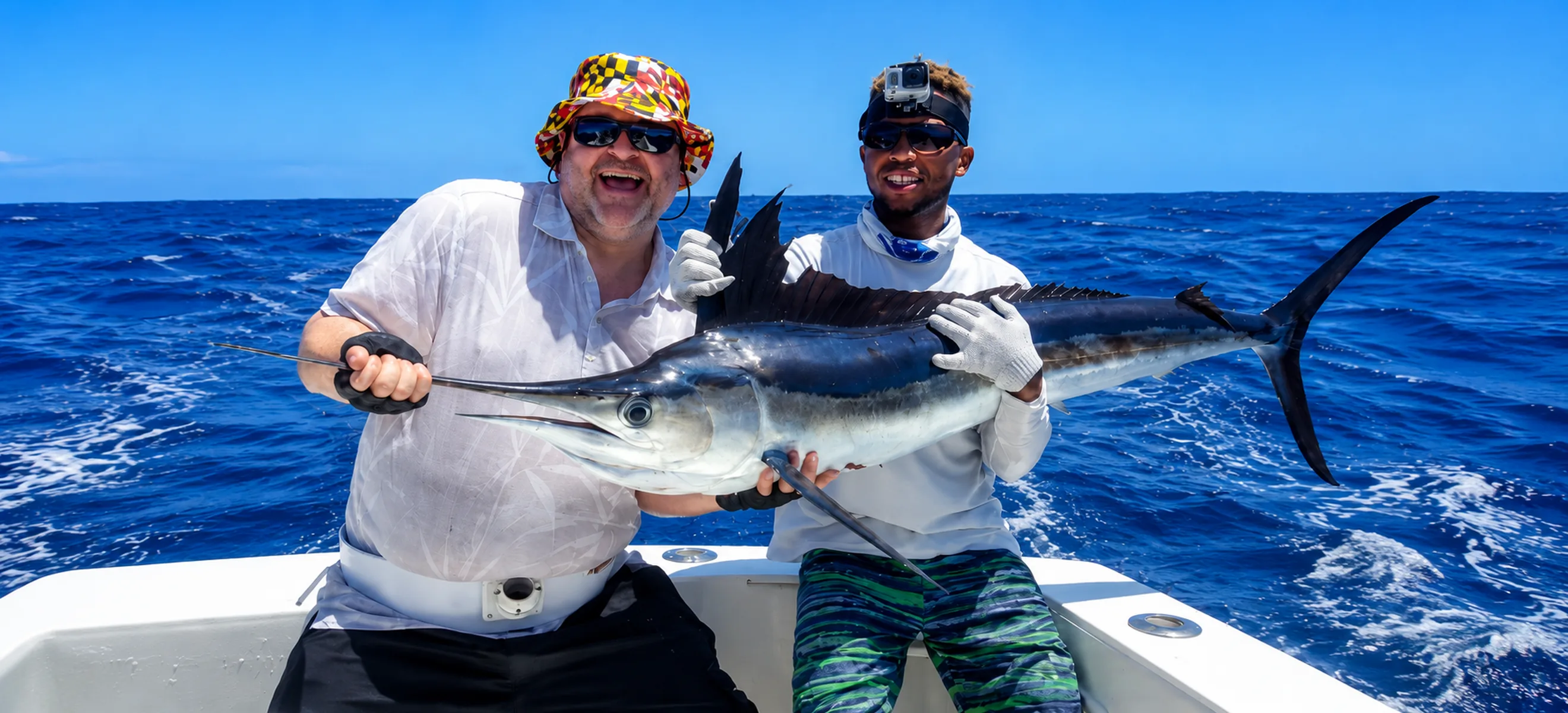 Happy anglers holding a freshly caught blue marlin during a deep sea fishing charter in Punta Cana, Dominican Republic, aboard a luxury sport fishing boat. 
