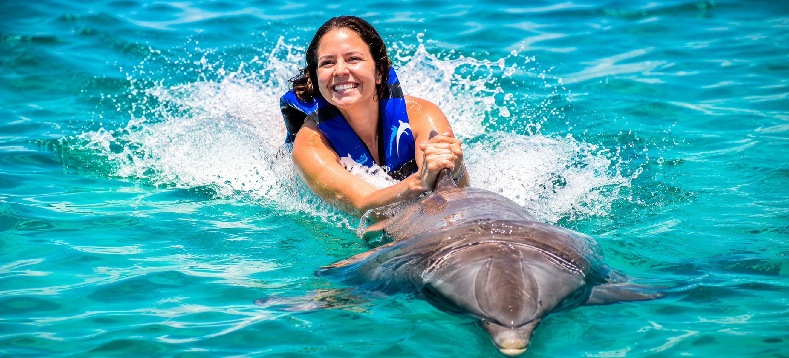 Guest enjoying the famous dolphin belly ride during the Dolphin Explorer experience in Punta Cana, Dominican Republic.