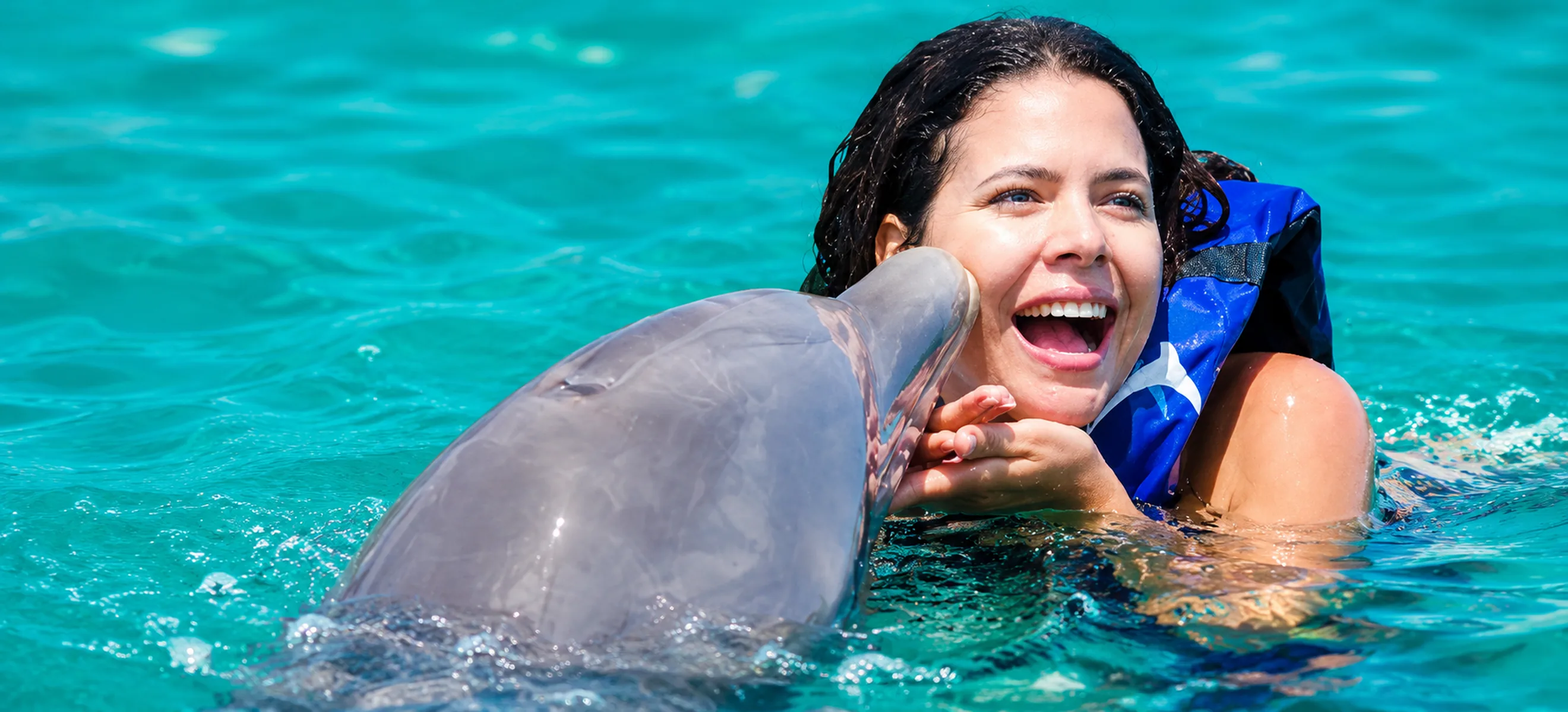 	Guest sharing a joyful dolphin kiss during the Dolphin Explorer experience in Punta Cana, Dominican Republic.