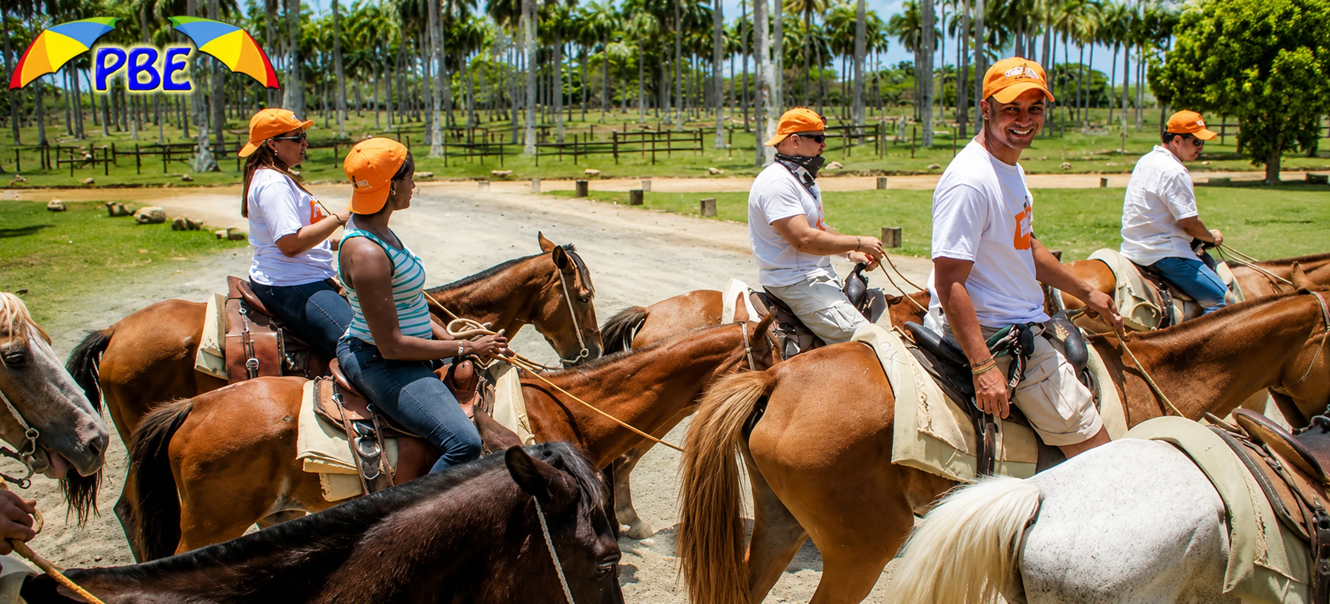 Guests enjoying a guided horseback riding tour through a tropical ranch surrounded by palm trees in Punta Cana, Dominican Republic.