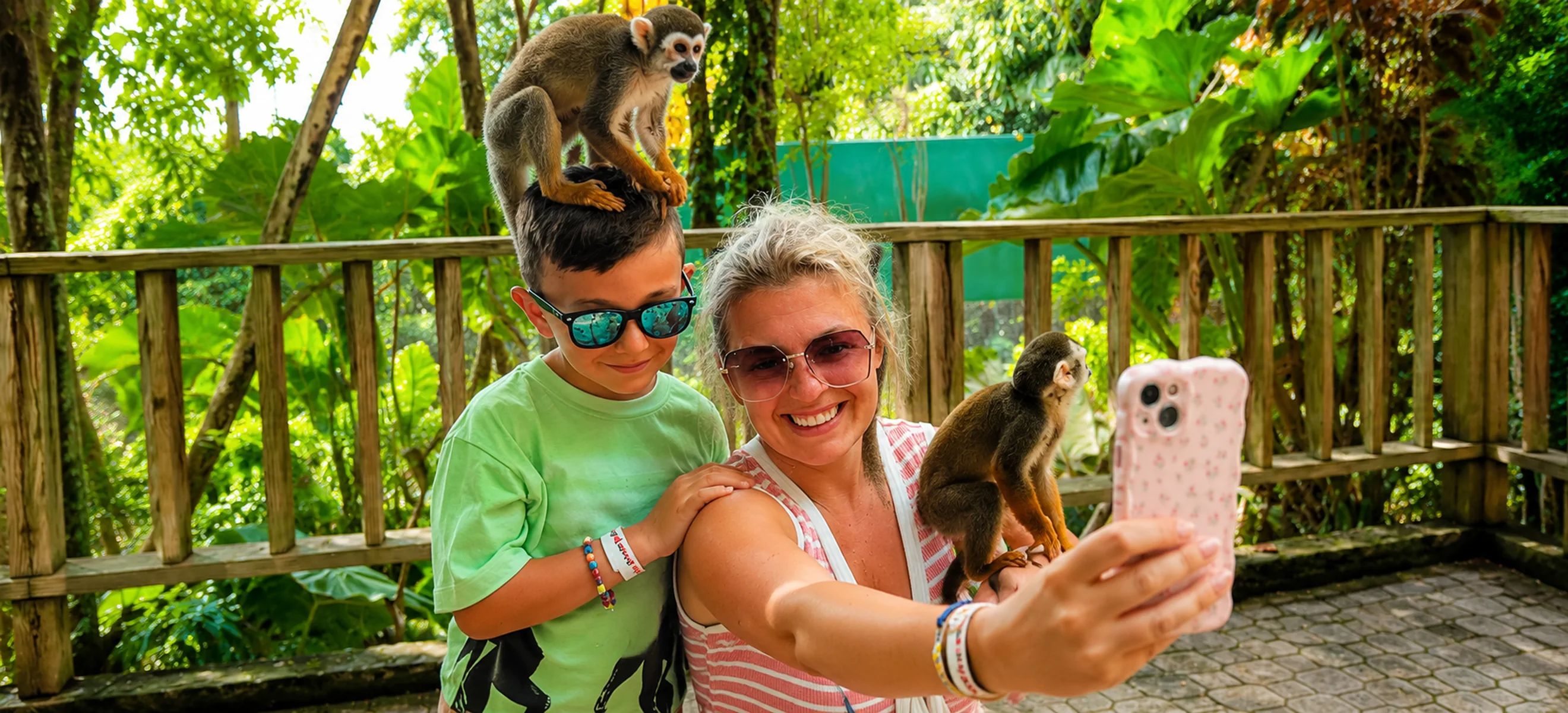 Family taking a selfie with friendly squirrel monkeys at Monkeyland Punta Cana, enjoying one of the Dominican Republic