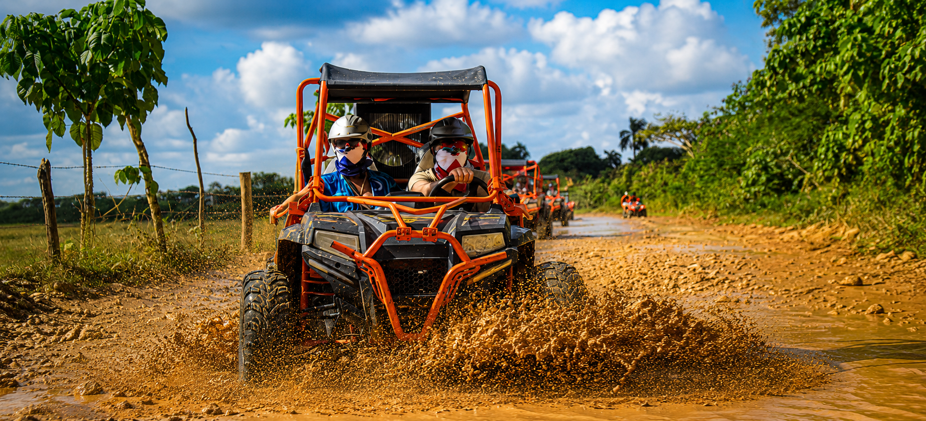 Wild Trails Buggies convoy driving through muddy off-road trails during an exciting adventure tour in Punta Cana, Dominican Republic.