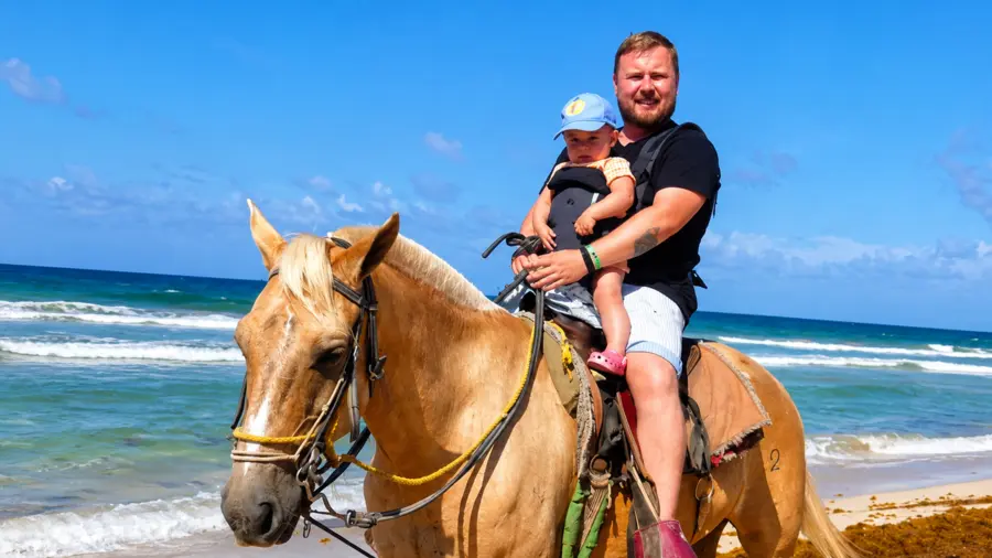 Family enjoying a beach horseback riding excursion in Punta Cana