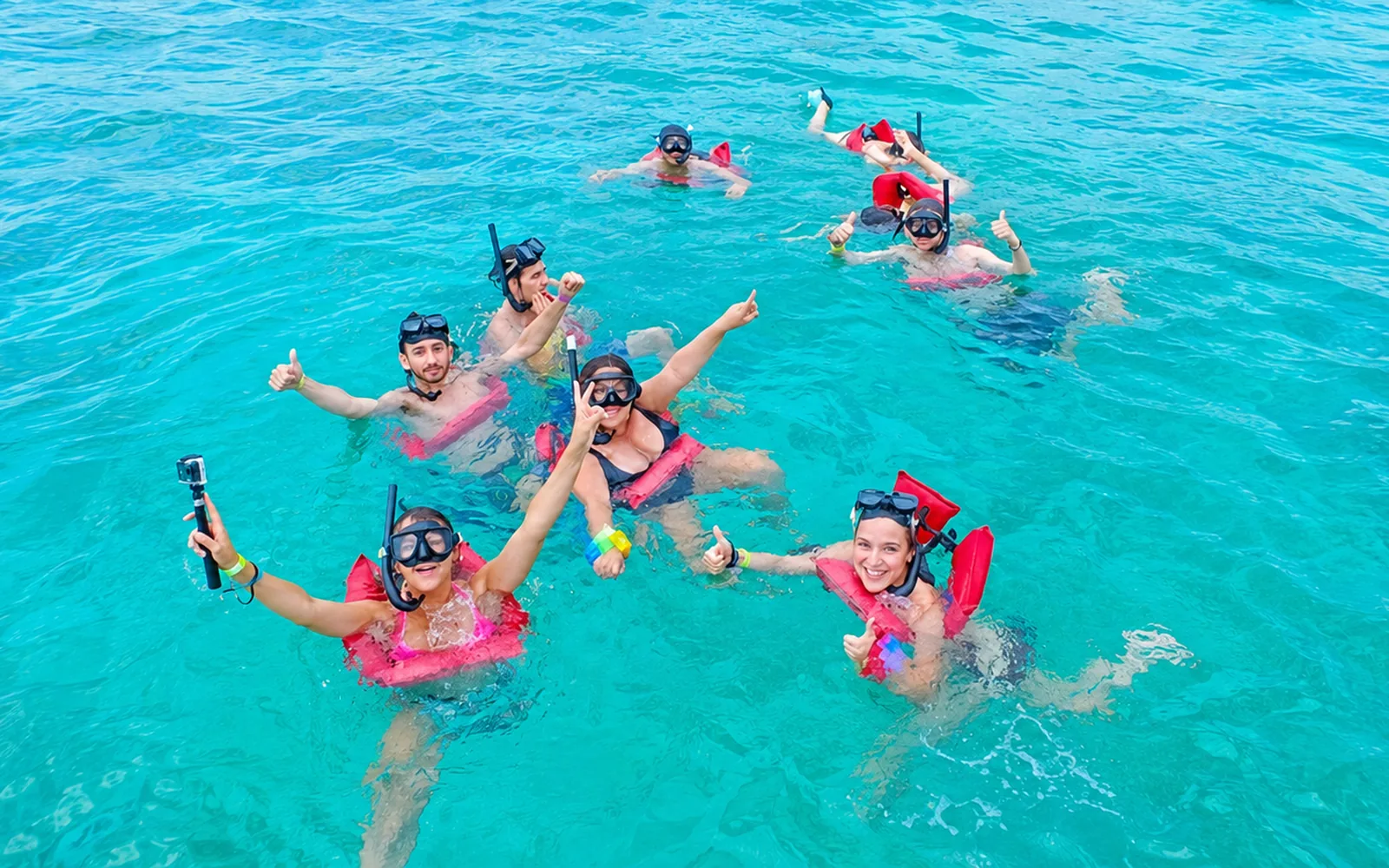 Group of travelers snorkeling in turquoise Caribbean water during a Saona Island excursion